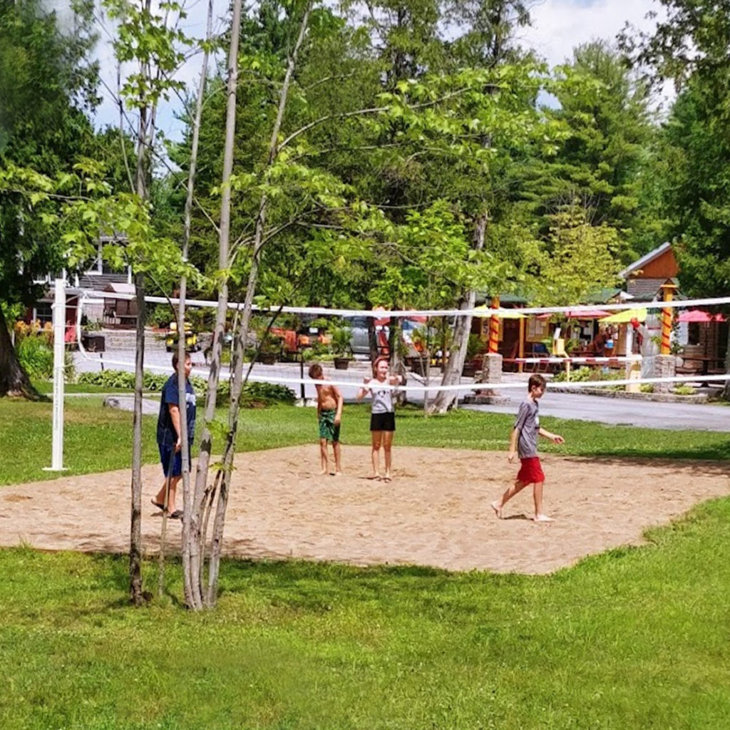 Kids playing volleyball at the outdoor volleyball court at Harmony Resorts - Ottawa East in Alfred Ontario.